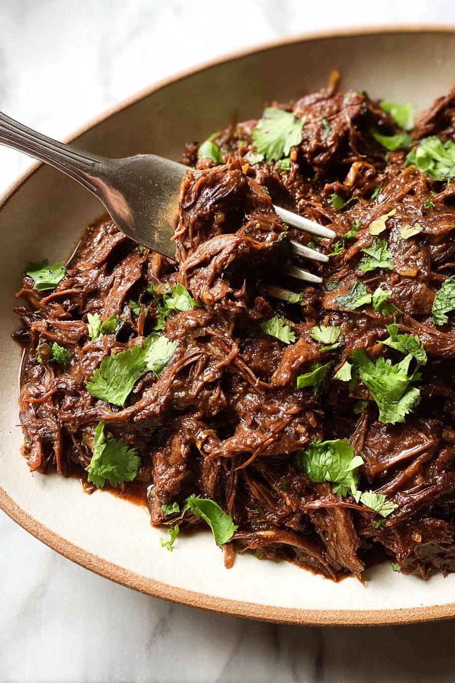 A close-up of a shallow white oval bowl filled with shredded dark brown beef stew layered with small pieces of green cilantro leaves scattered on top, with a shiny metal fork lifting some beef from the right side, all set on a white marbled surface photo taken with an iphone --ar 2:3 --v 7