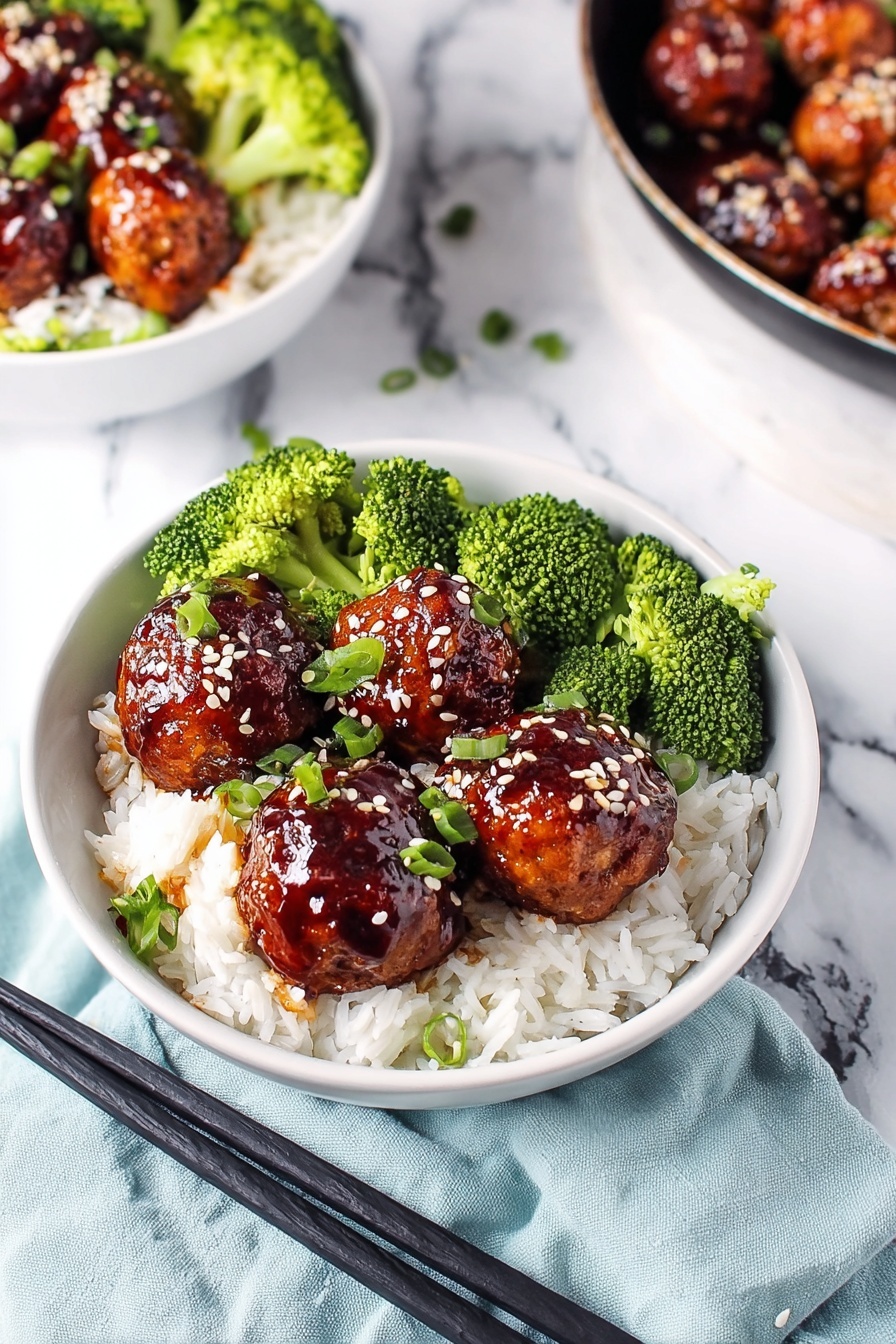 A white bowl shows a meal with three parts: at the bottom there is a layer of white rice with soft grains, on the left and center sit shiny brown meatballs with a sticky glaze, sprinkled with white and black sesame seeds and small green onion pieces, and on the right is a group of bright green broccoli florets with a fresh texture; the bowl sits on a white marbled surface with black chopsticks placed near the bowl's edge, and a small round dish with mixed white and black sesame seeds is near the top edge of the image, photo taken with an iphone --ar 2:3 --v 7