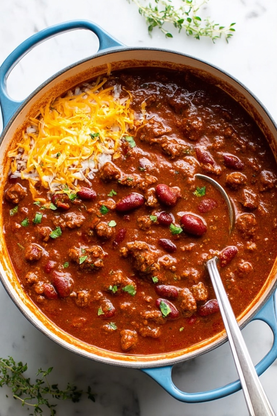 A large round blue pot filled with thick reddish-brown chili. Inside, there are chunks of cooked meat and red kidney beans spread throughout the rich sauce. On the top left side, there is a layer of shredded yellow cheddar cheese, and a dollop of white sour cream sits just above the cheese. Small green herb pieces are sprinkled across the chili adding a fresh touch. A silver ladle with a long handle rests inside the pot on the right side. The pot is placed on a white marbled surface with a few sprigs of green herbs nearby. Photo taken with an iphone --ar 2:3 --v 7