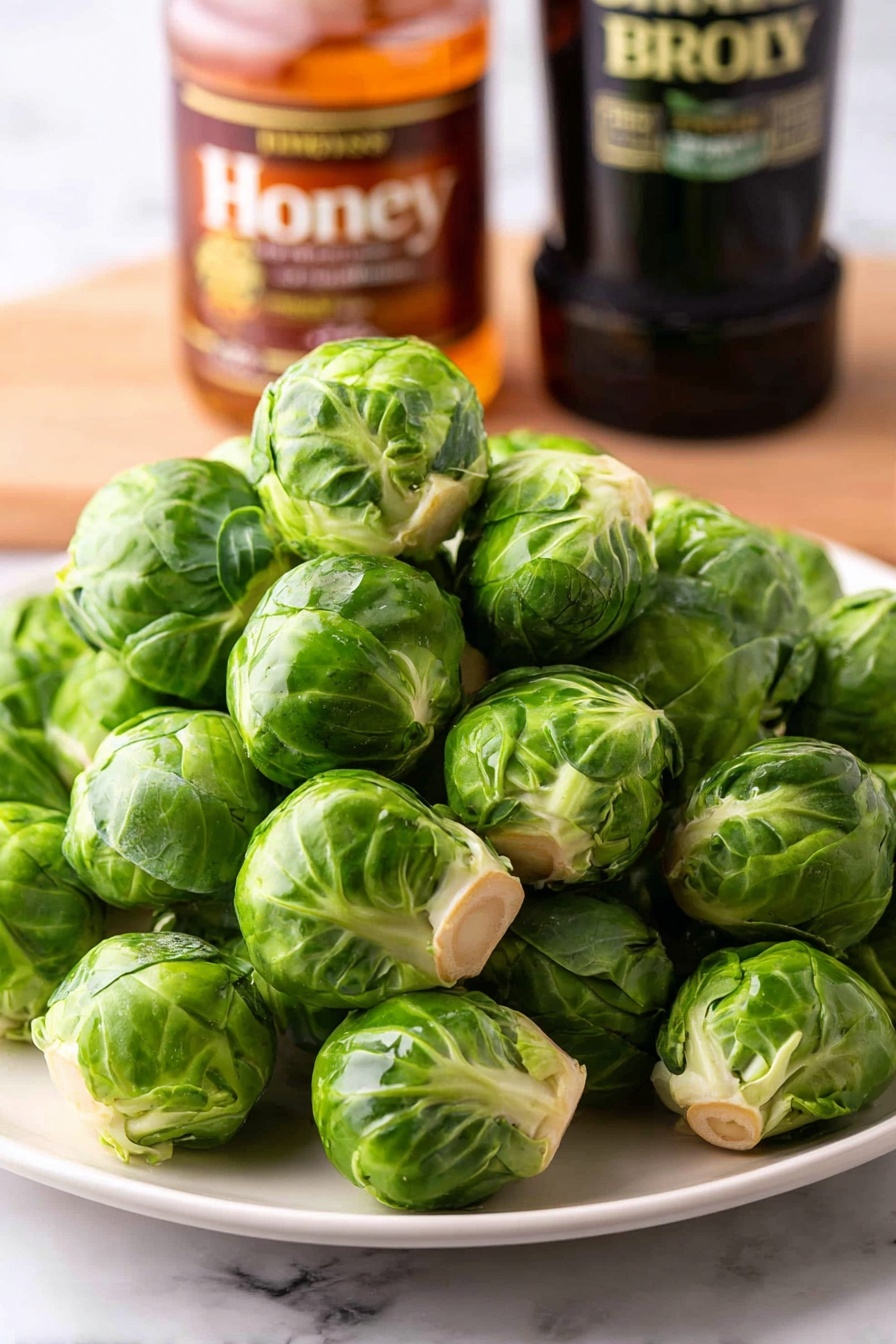 A white plate holds a dish of roasted Brussels sprouts, each piece cut in halves or smaller chunks showing a mix of green and brown crispy edges, glistening with a light sauce or oil. The Brussels sprouts have charred, dark brown spots, layered with tender green leaves and caramelized brown textures. A shiny silver fork is inserted into one Brussels sprout half near the front, showing the soft inside and crispy outside layers. The plate sits on a white marbled surface. Photo taken with an iphone --ar 2:3 --v 7