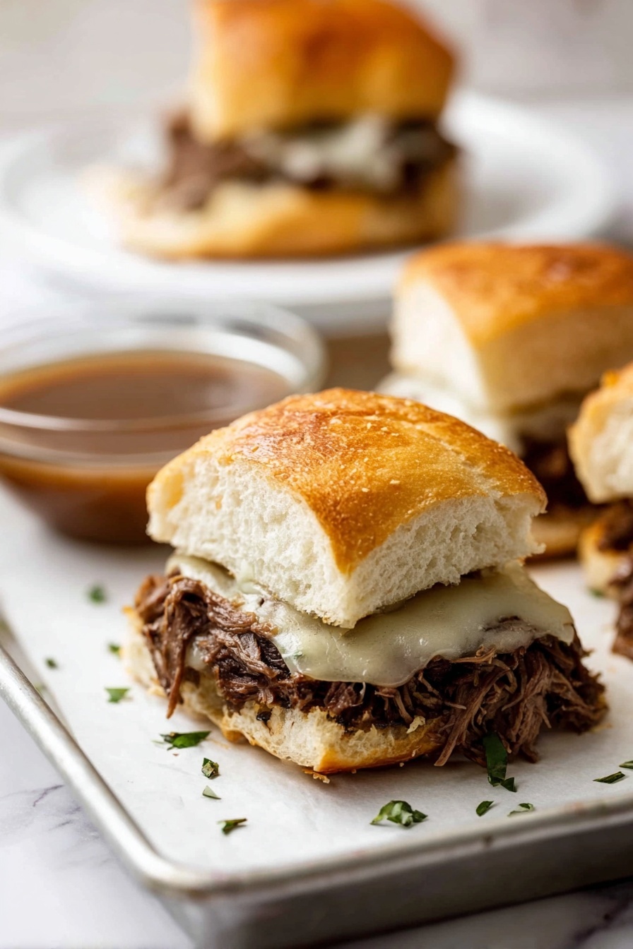 A close-up view of a sandwich with three layers: a golden, crusty white roll sliced open with a soft inside on top; in the middle, a thick layer of dark, shredded meat filling with a slightly rough texture; on the bottom of the meat, a melted layer of light-colored cheese that looks smooth and soft, melting slightly over the meat; the sandwich is on a piece of white paper on a metal tray, with small green herb pieces sprinkled around. In the blurry background, there is another sandwich on a white plate and a glass bowl with brown sauce, all on a white marbled surface. photo taken with an iphone --ar 2:3 --v 7