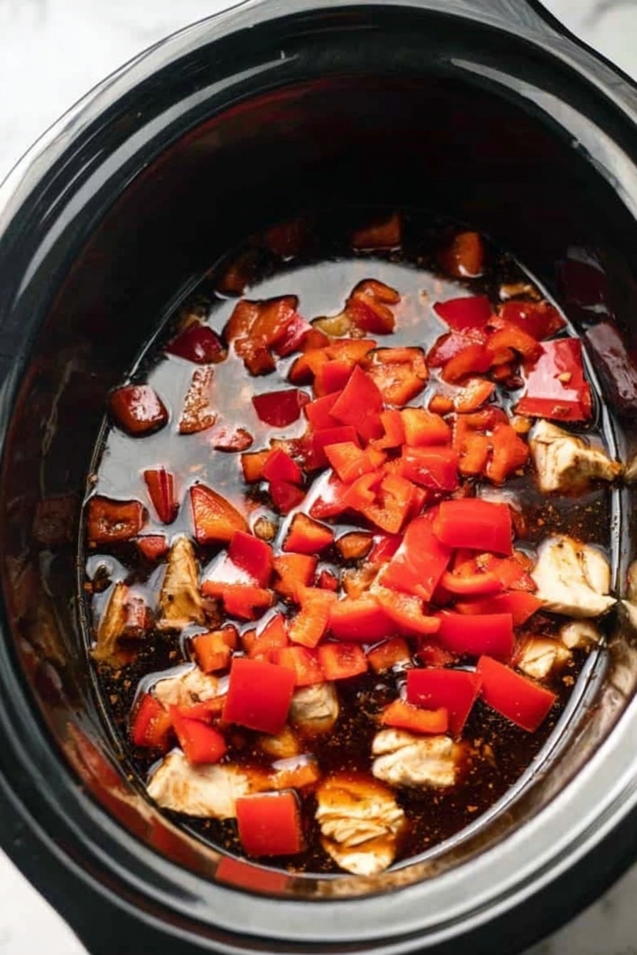 The dish shows a white bowl filled with a layer of white rice topped with golden brown chicken pieces covered in a shiny, sticky sauce. Scattered among the chicken are whole, lightly roasted cashew nuts with a smooth texture. Bright green chopped scallions are sprinkled on top, adding color contrast. The bowl sits on a white marbled surface with a few cashew nuts and scallion pieces around it. Photo taken with an iphone --ar 2:3 --v 7